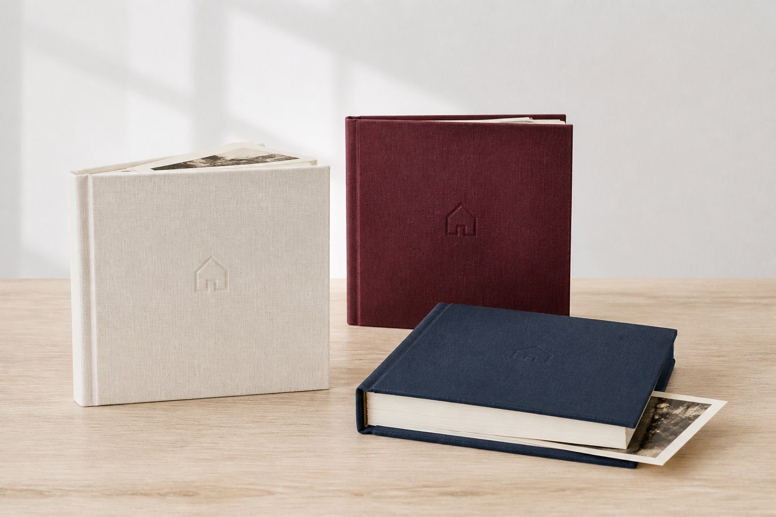 Collection de trois livres souvenirs en lin ivoire, bordeaux et bleu nuit